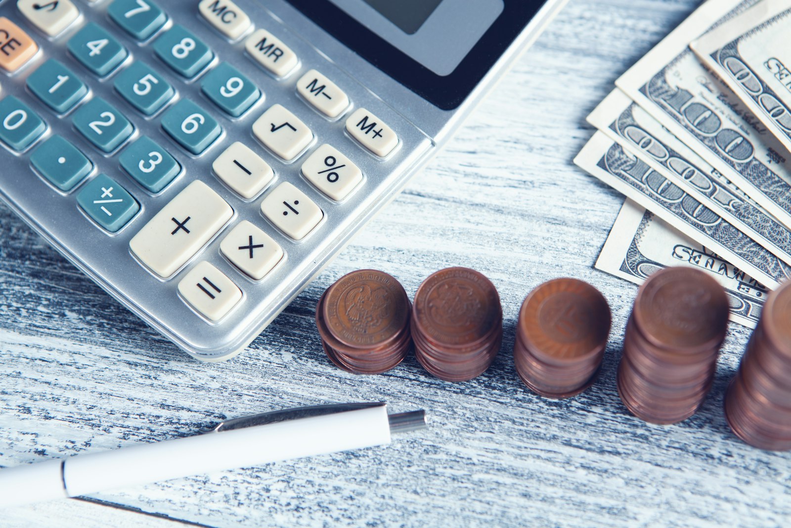 Calculatrice, stylo et pièces de monnaie